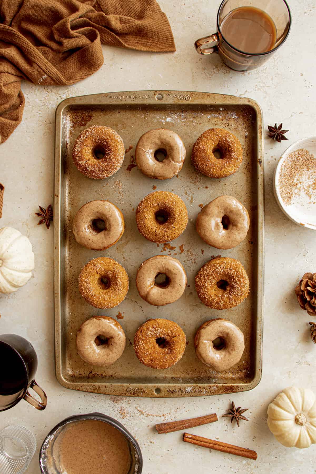 Baking tray with sugar coated and glazed pumpkin donuts. 