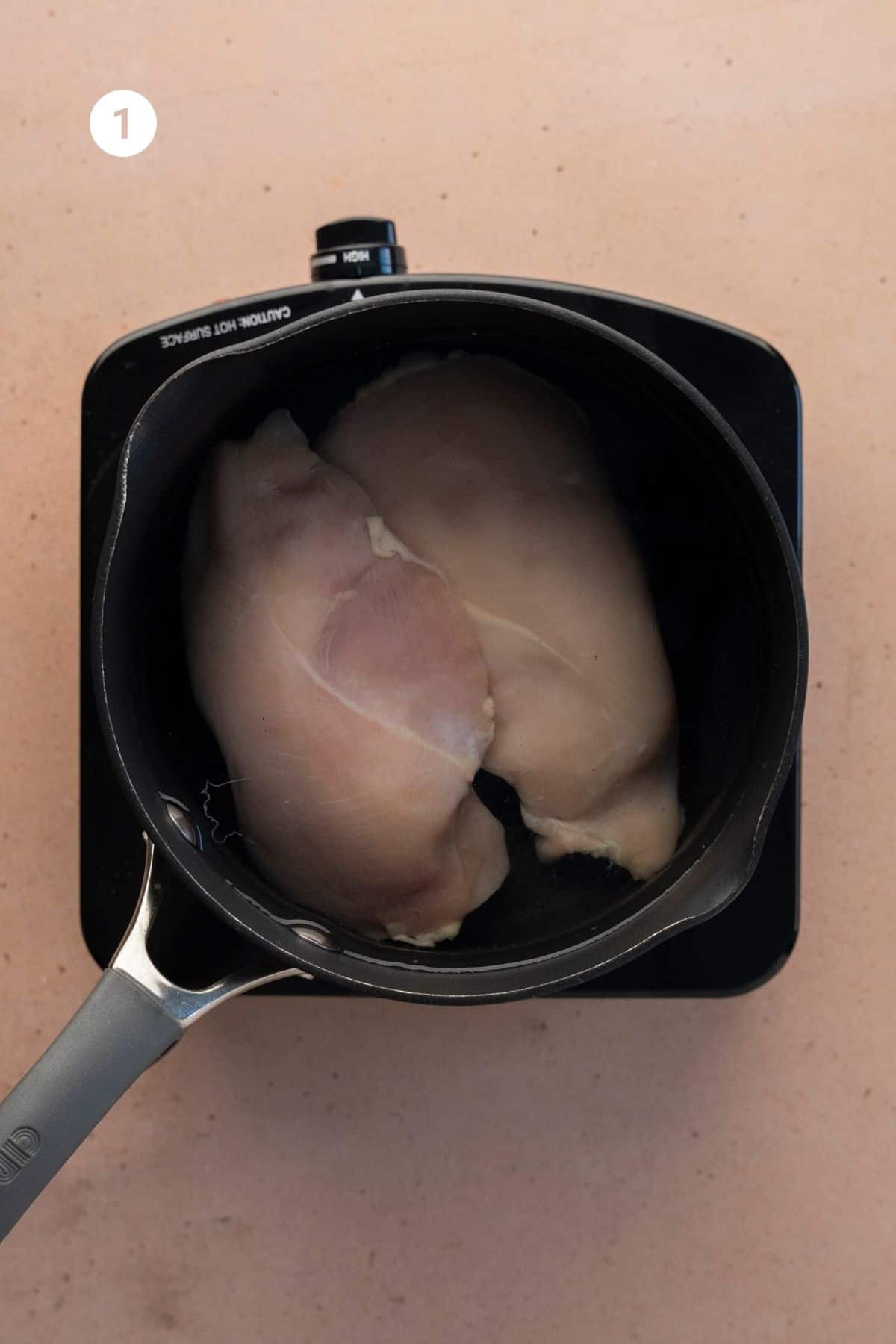 Raw chicken in a pot of water. 