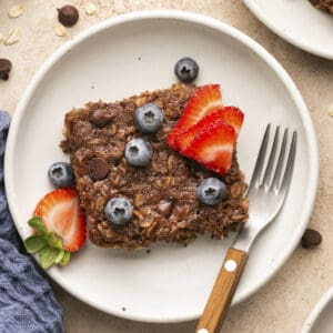 Chocolate baked oatmeal with berries on top plated with a fork.