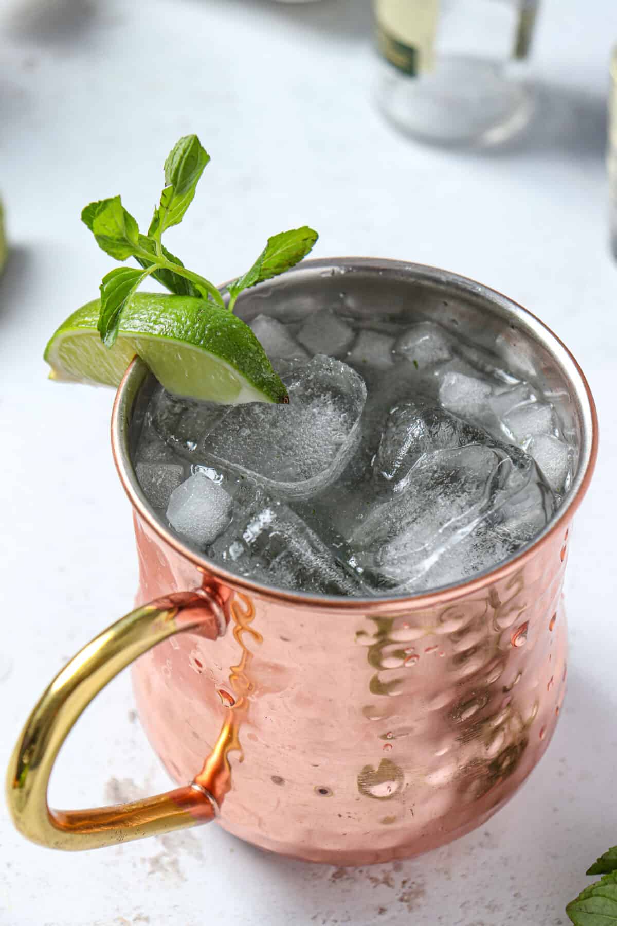 Non alcoholic mule with mint and lime garnish in a copper mug. 
