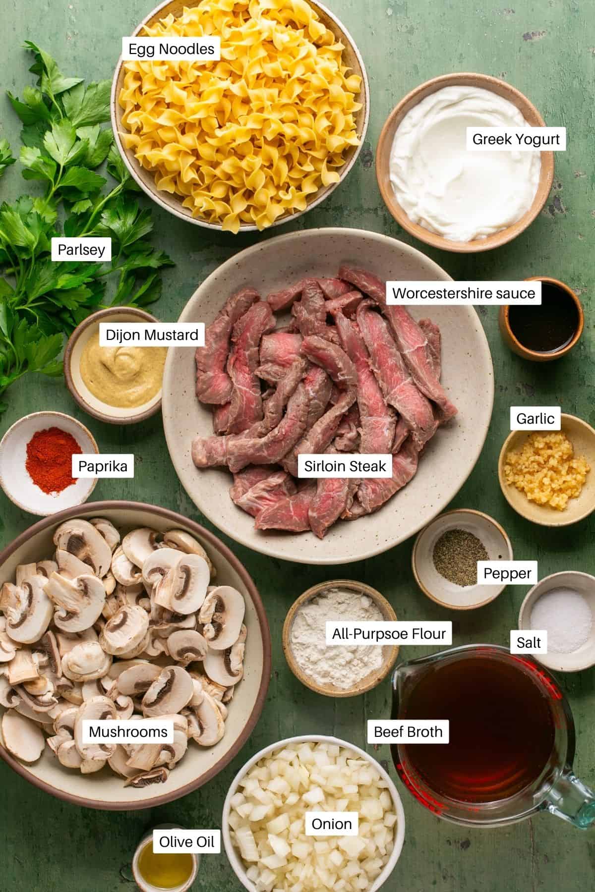 Sliced beef, mushrooms, egg noodles, greek yogurt, spices, broth and parsley for the dish. 