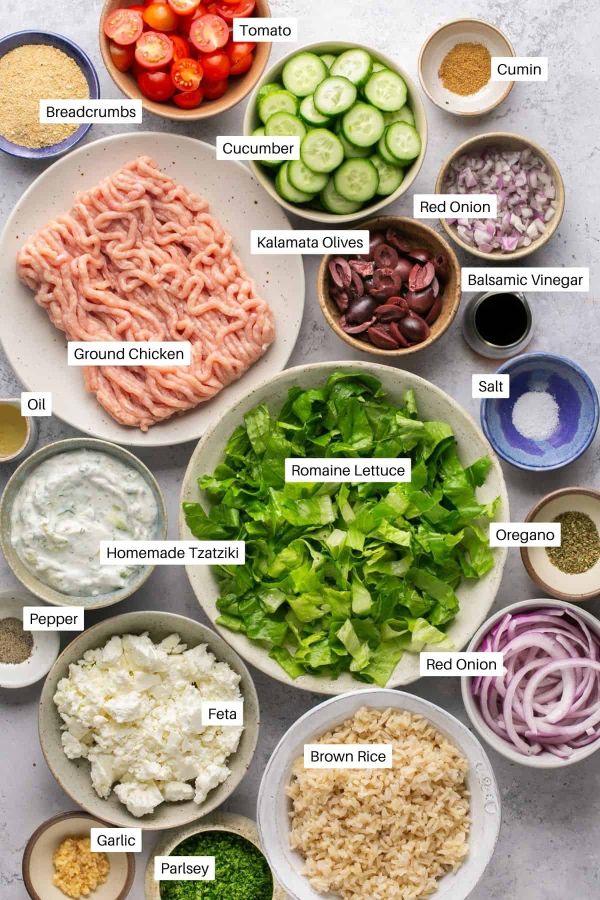 Ingredients for bowls. Ground chicken, fresh vegetables, tzatziki, brown rice, lettuce and seasonings. 