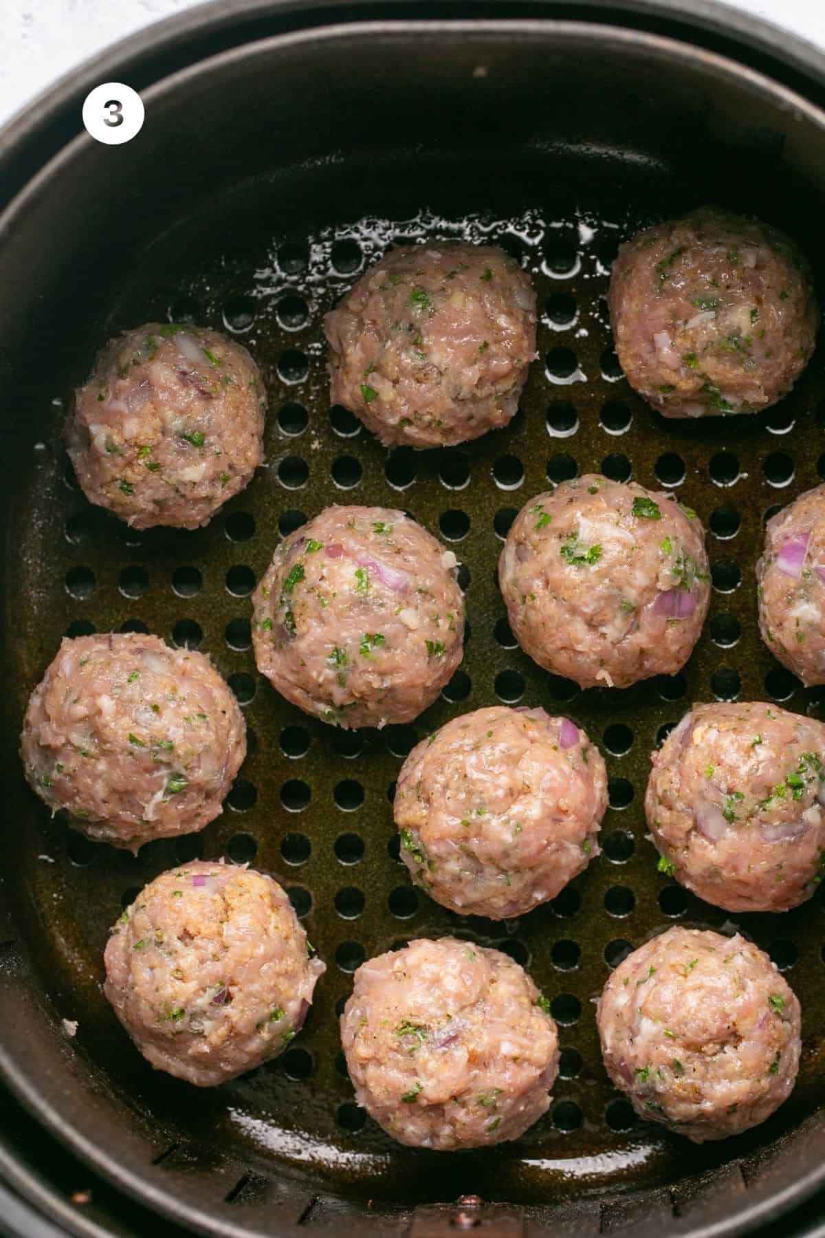 Mixture formed into meatballs and in the air fryer basket. 