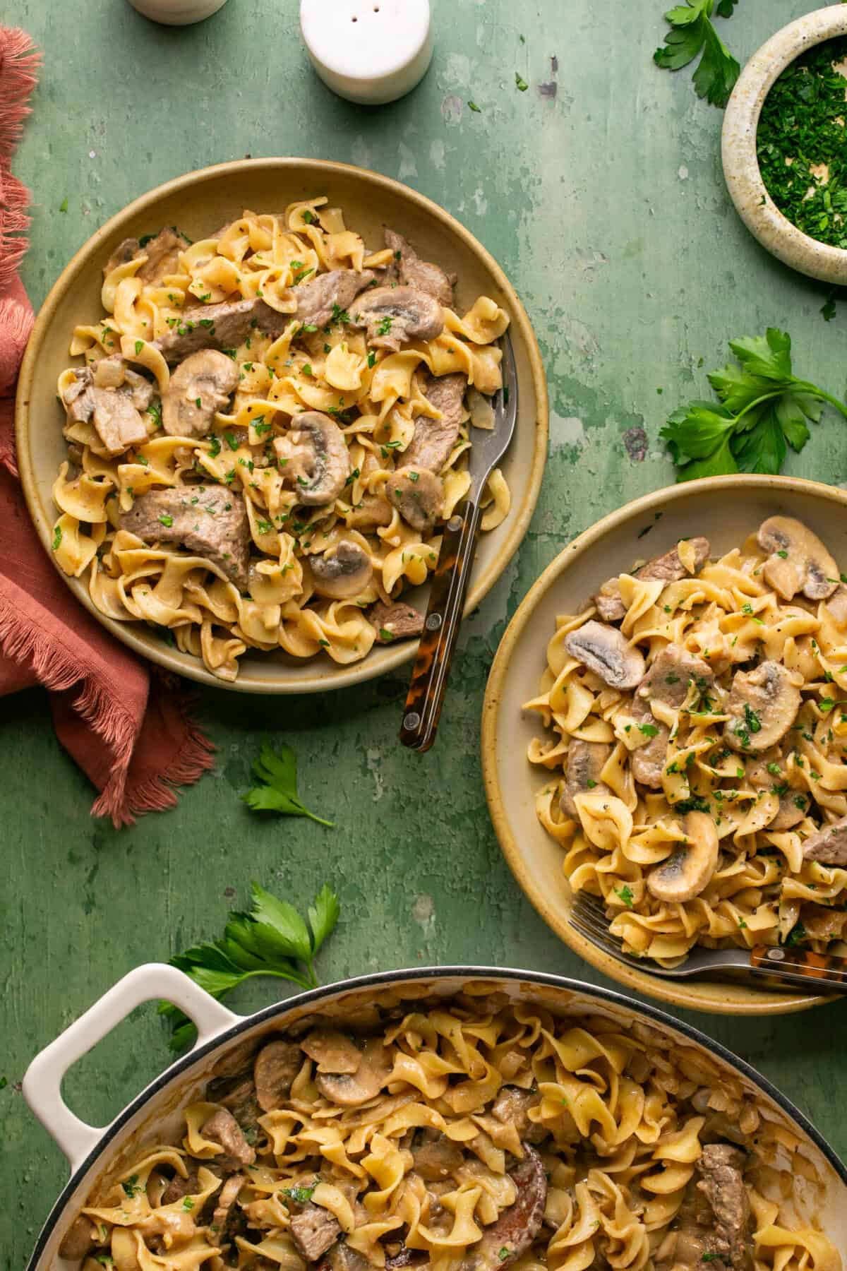 Stroganoff in serving bowls with fresh chopped parsley on top. 