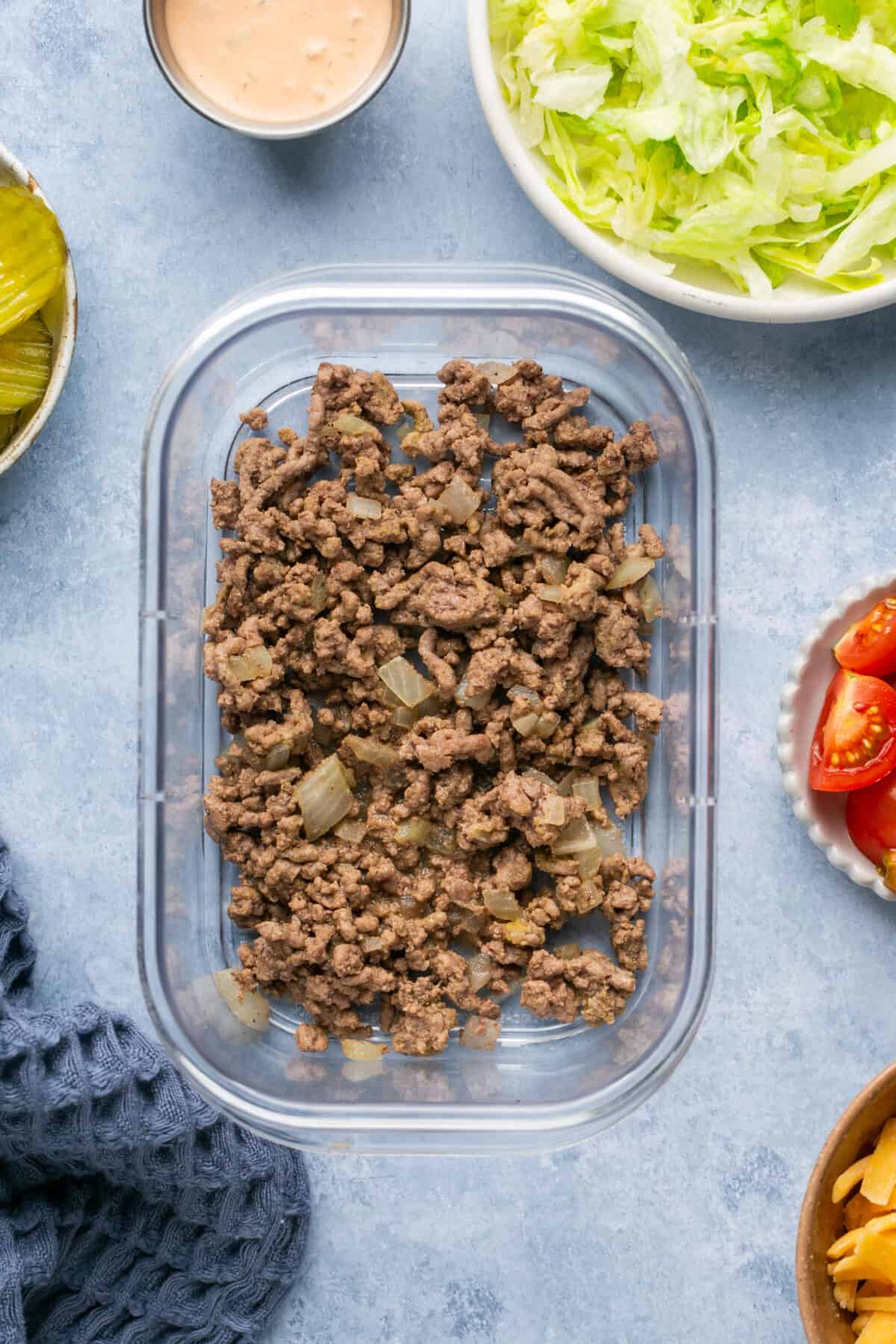 Meat added to a meal prep container. 