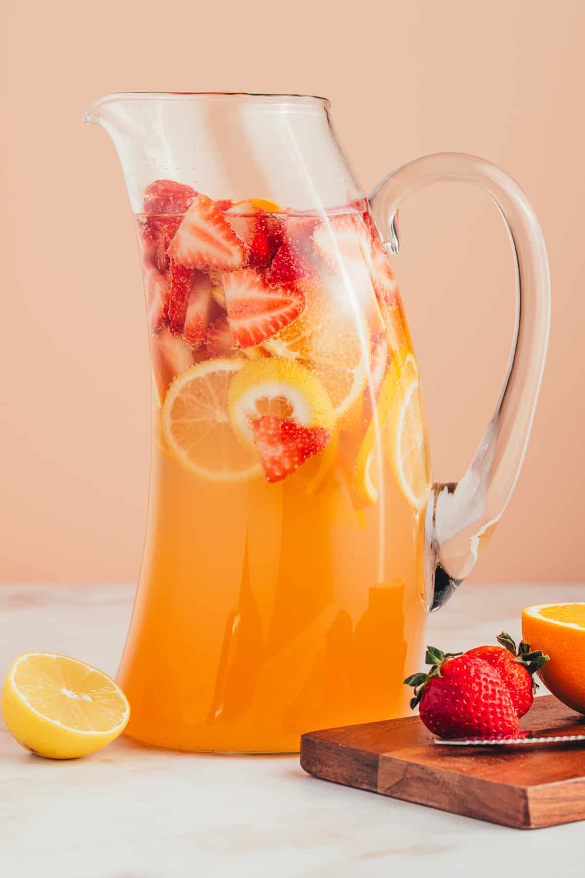 Pitcher full of non alcoholic sangria with sliced fruit inside.