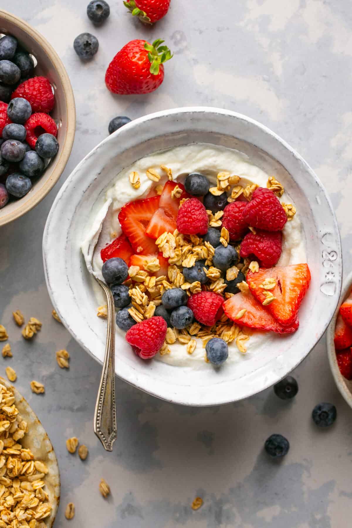 Classic berry yogurt bowl with sliced strawberries, blueberries and granola on top. 