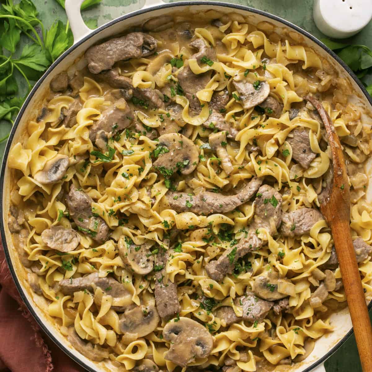 Beef stroganoff in a pan with a spoon to serve.