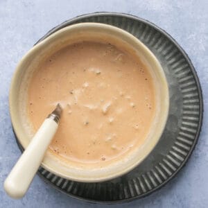 Creamy sauce in a small bowl with a spoon.