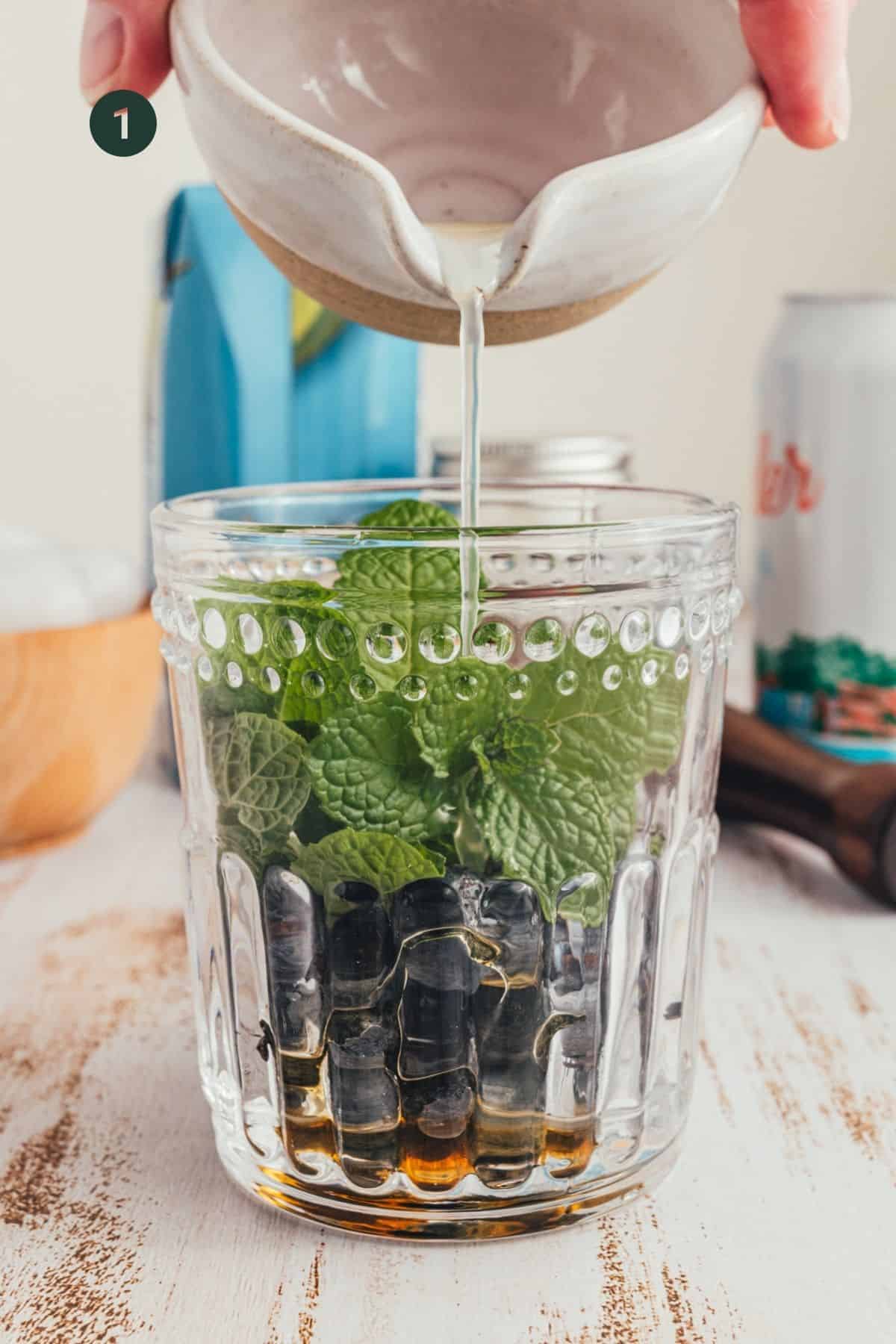 Mint, blueberries and honey in a cup.