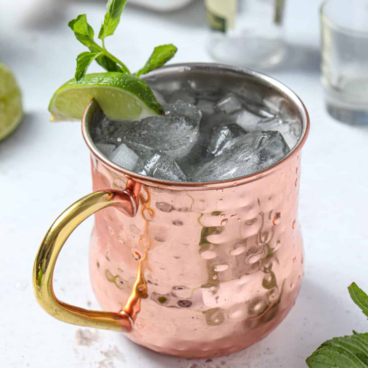 Non alcoholic classic mule with lime and mint for garnish in a copper mug.