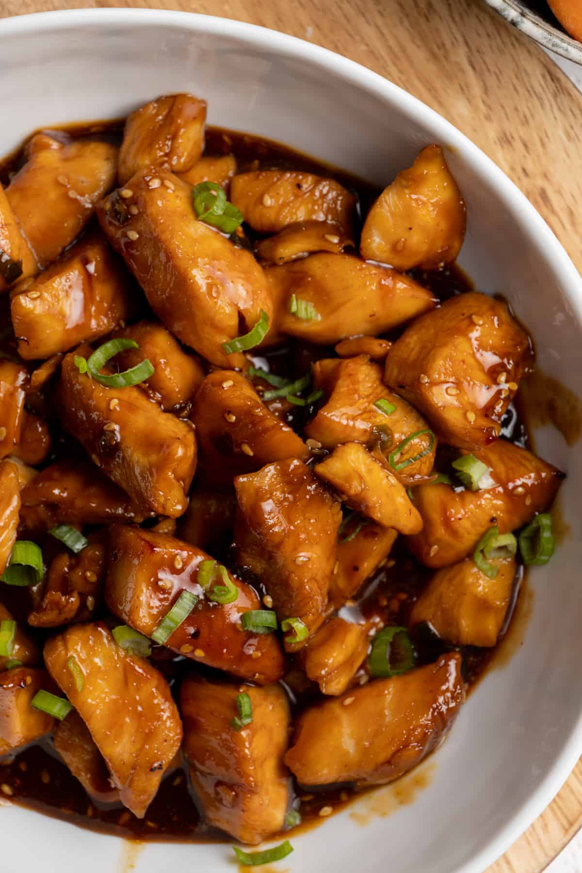Teriyaki chicken with green onions in a bowl. 