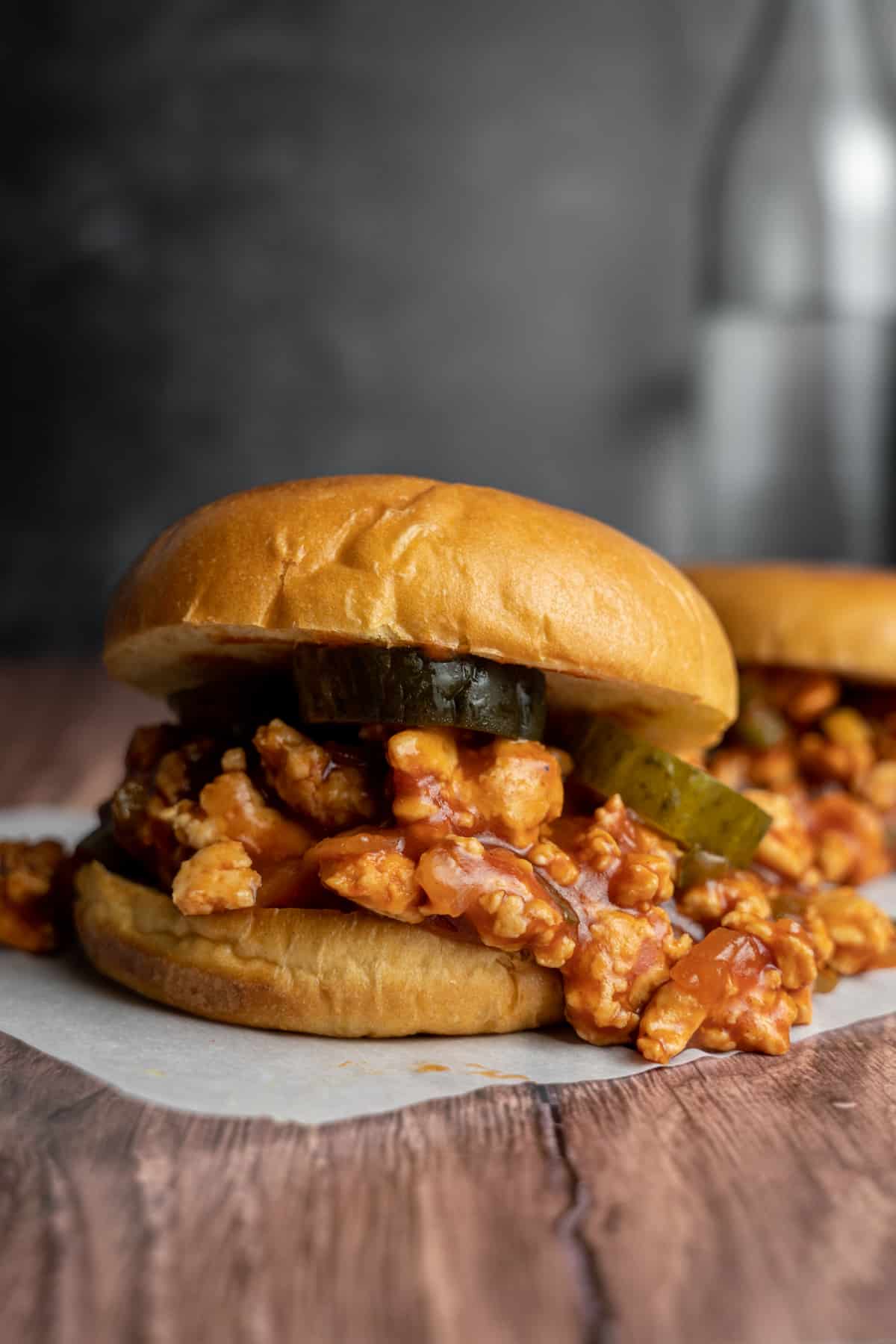 Ground chicken sloppy joes on a bun with pickles. 