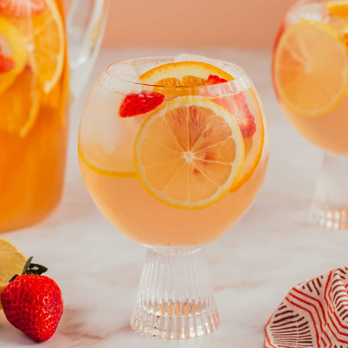 Sangria mocktail poured into a glass with sliced fruit.