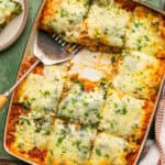 Lasagna cut into 12 squares with 2 out and plate nearby.