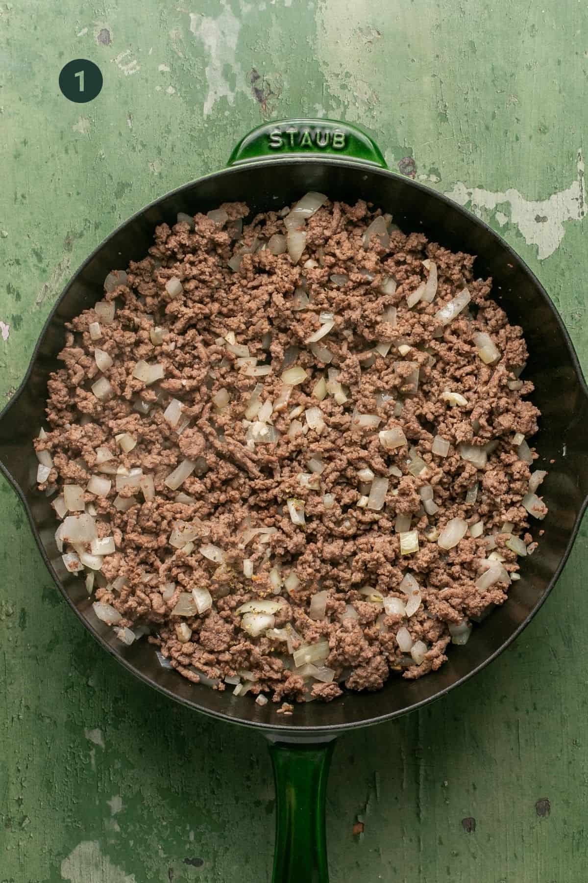 Onions, garlic and browned ground beef in a skillet. 