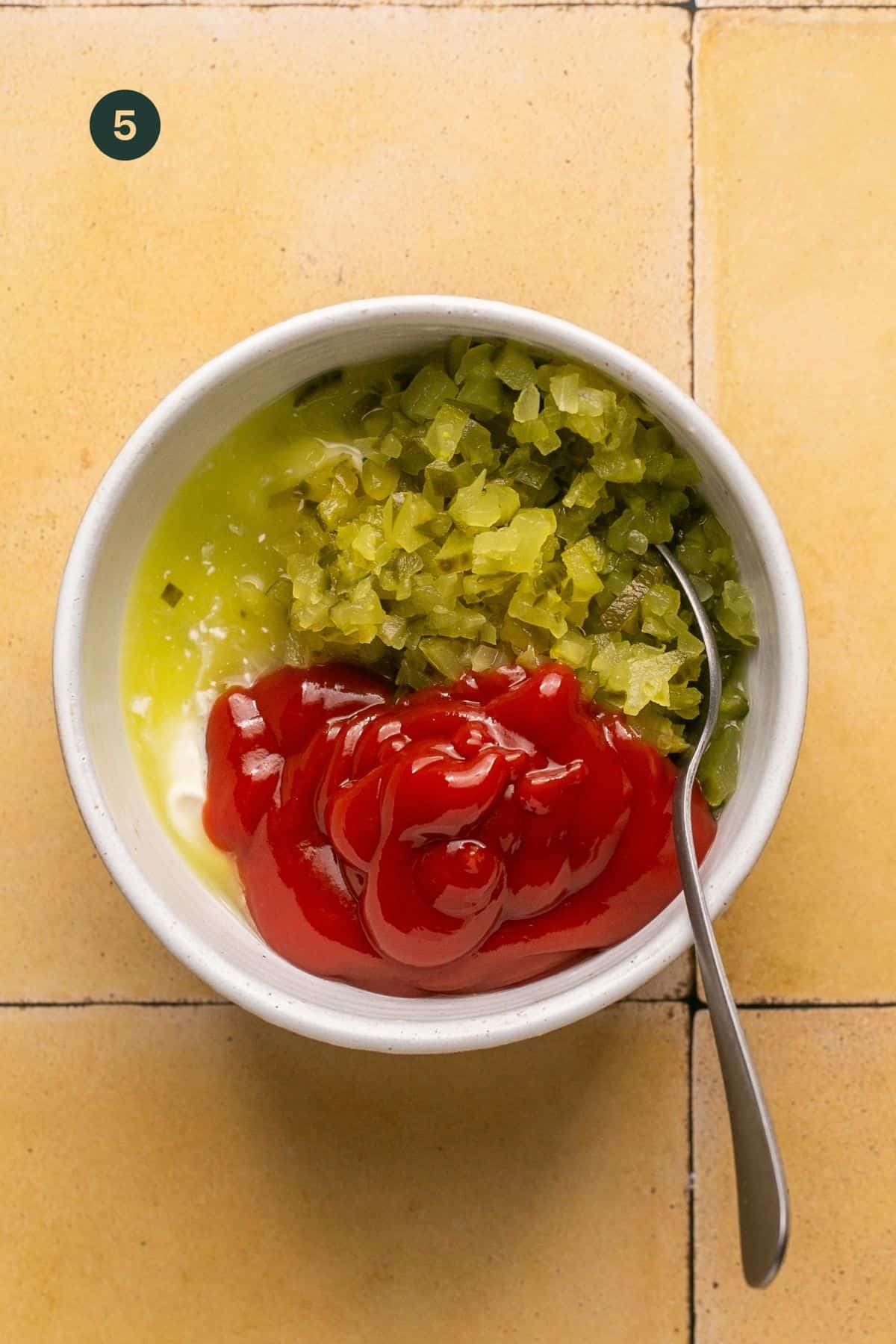 Chopped pickles, pickle juice, mayonnaise and ketchup in a small bowl.