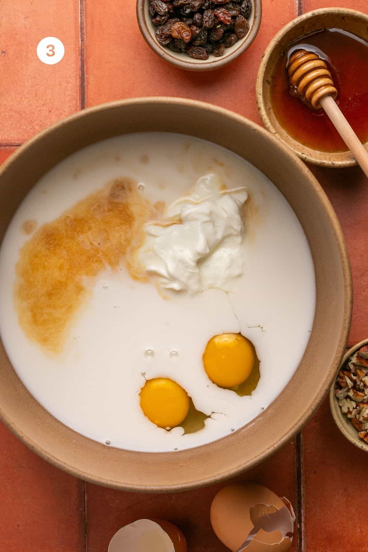 Eggs, almond milk, greek yogurt, vanilla extract and honey added to a mixing bowl. 
