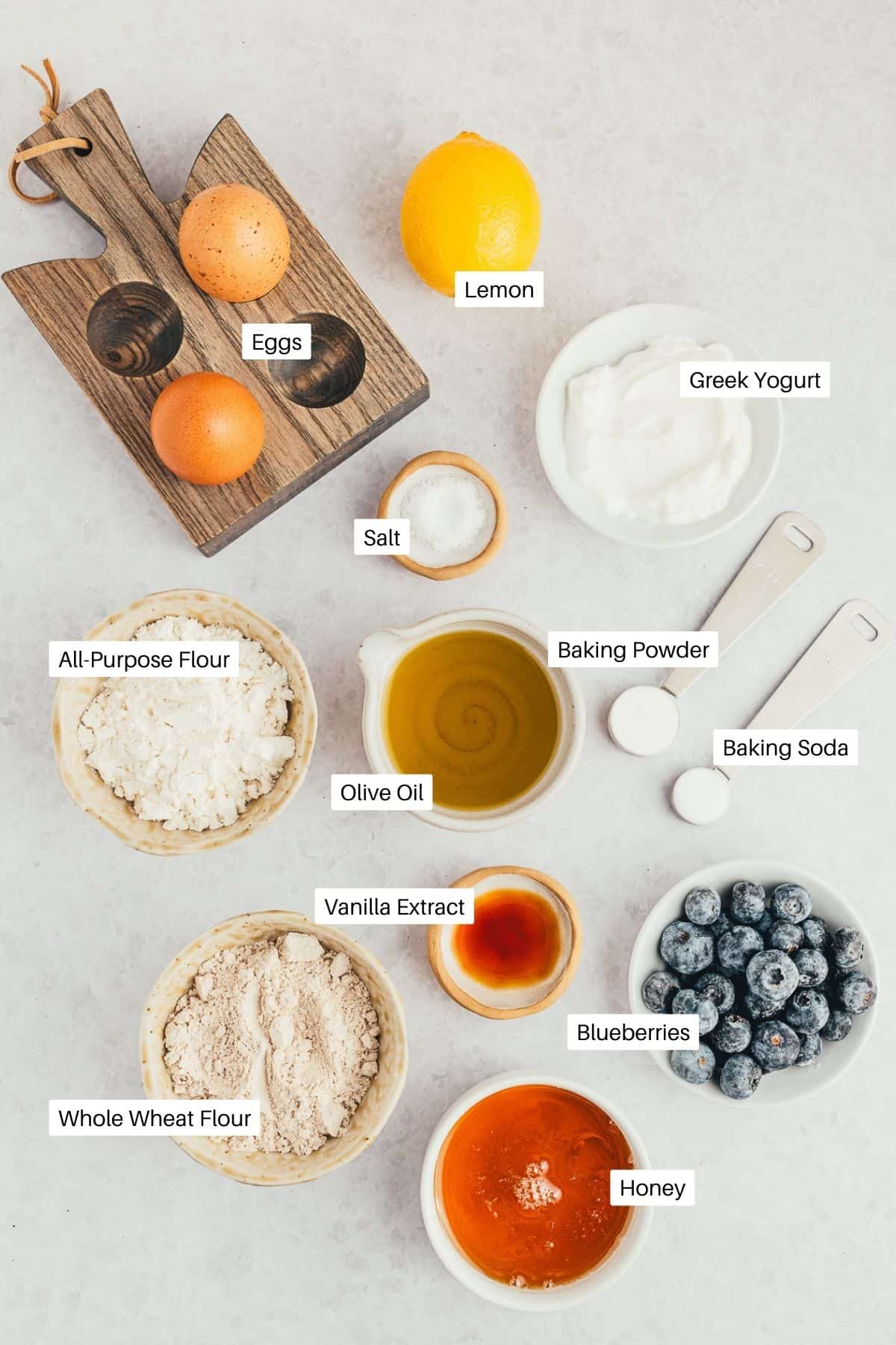 Lemon, eggs, greek yogurt, oil, flours, vanilla, blueberries and honey for the muffins. 