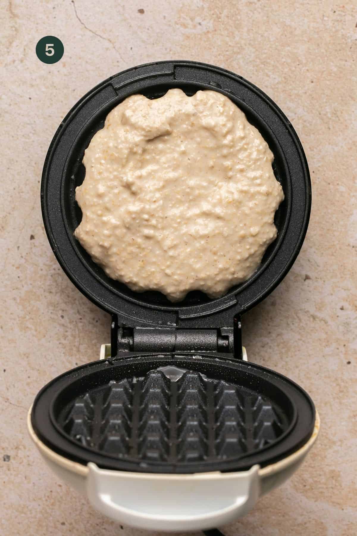 Batter added to a hot waffle maker.