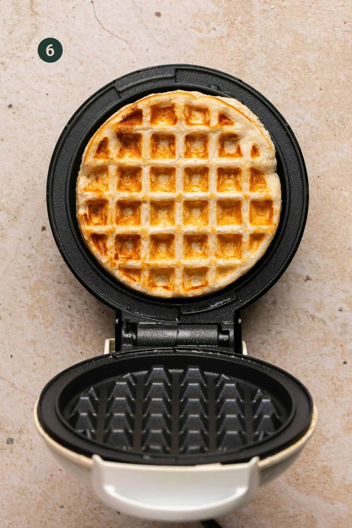 Fully browned and cooked waffle in a waffle maker.