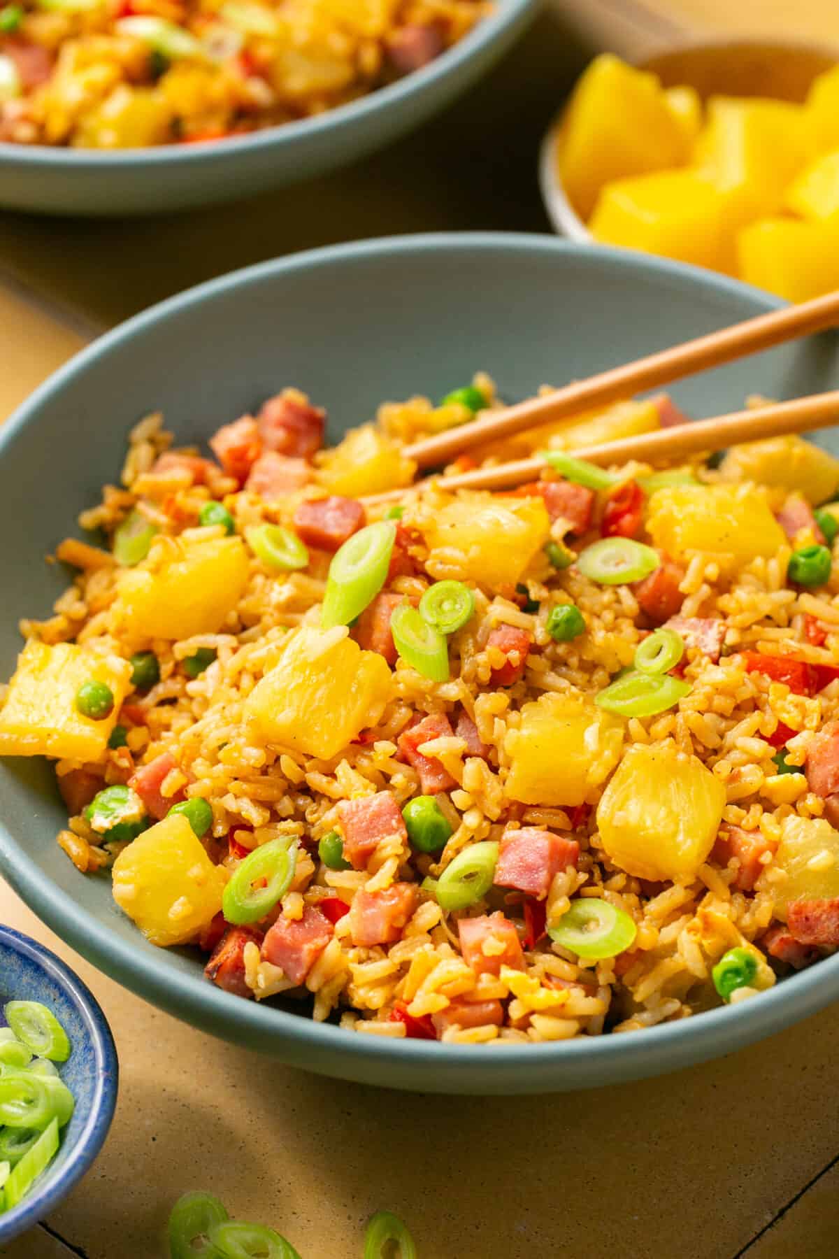 Bowl of ham and pineapple fried rice with chop sticks.
