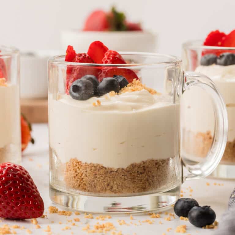 Fully set cheesecake cup with berries on top.