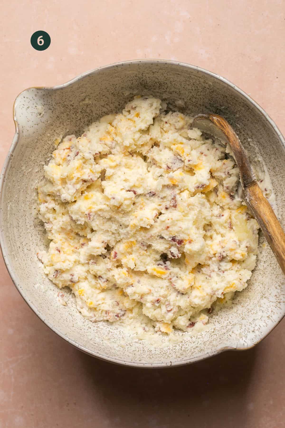 Mashed potatoes in a bowl with bacon, cheese and yogurt mixed in. 