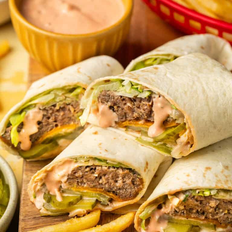 Four wraps filled with cooked burgers, lettuce, cheese, pickles and Big Mac sauce with a side of fries.