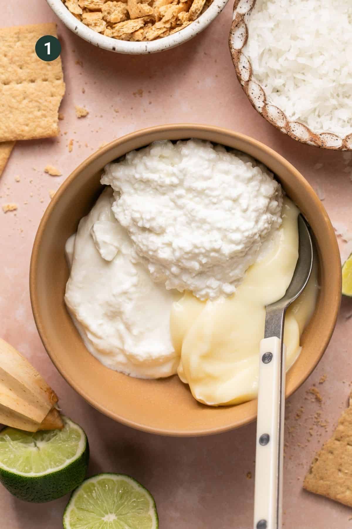 Cottage cheese, greek yogurt and vanilla pudding in a bowl with a spoon. 