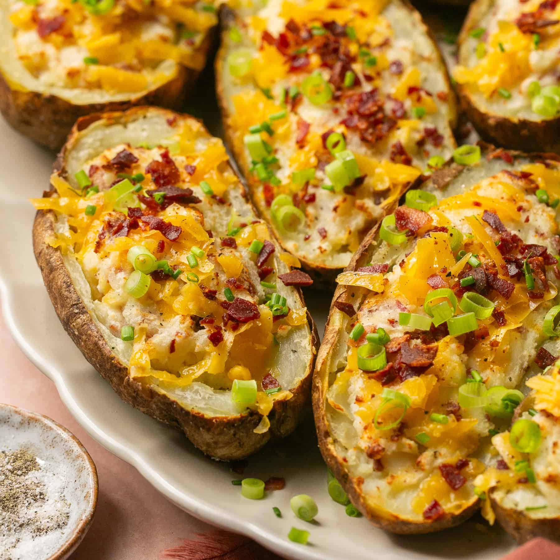 5 twice baked potatoes topped with bacon, cheese and green onions.