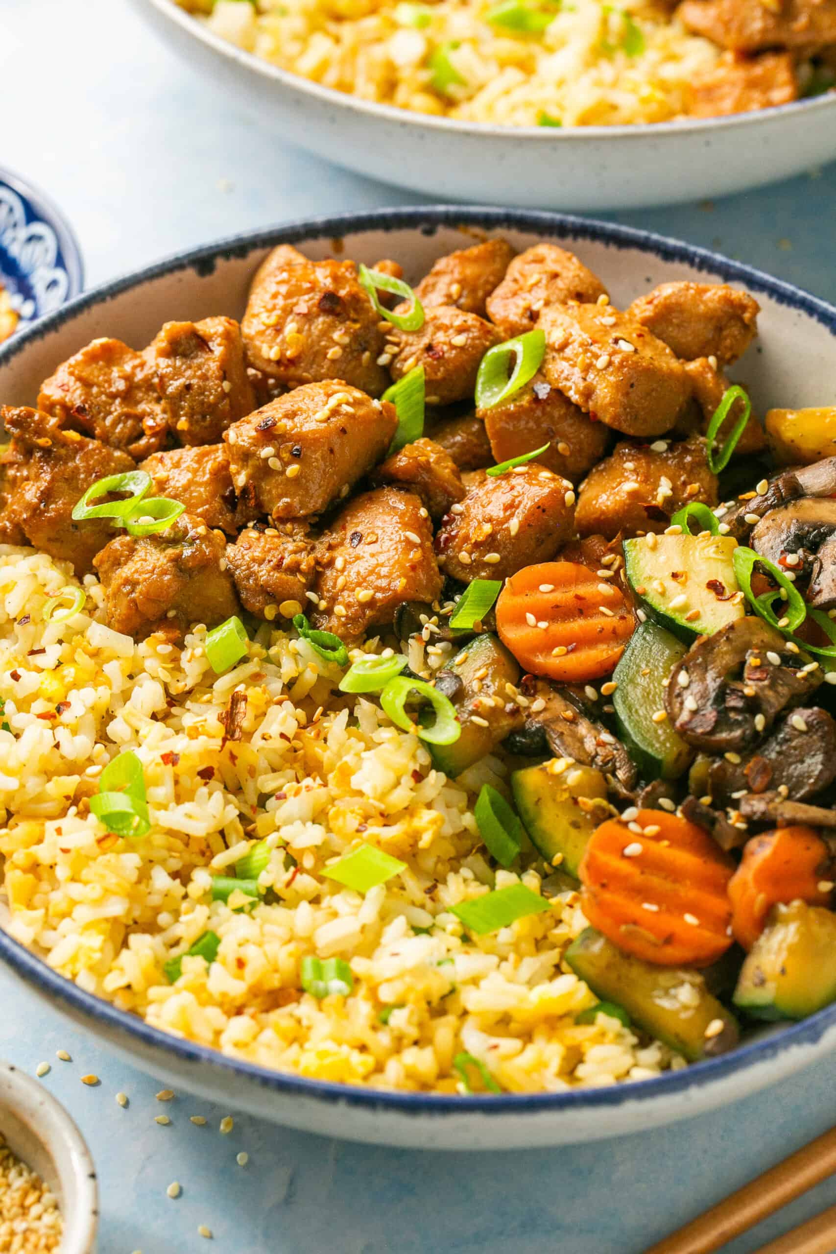 Homemade hibachi bowls with marinate chicken breast, fresh sauteed veggies and a blend of white rice and cauli rice in a bowl.