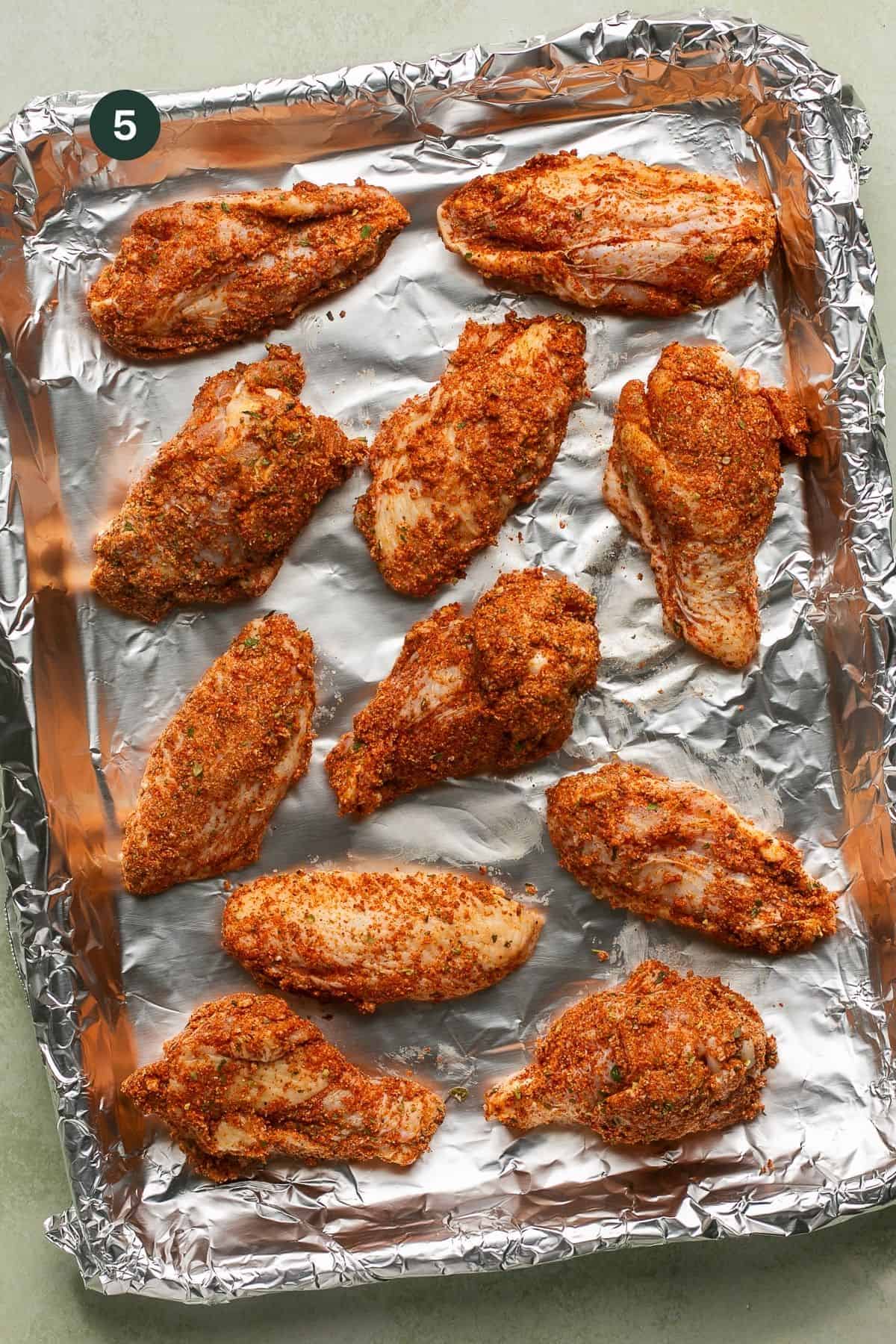 Wings laid out on a foil lined pan to bake.