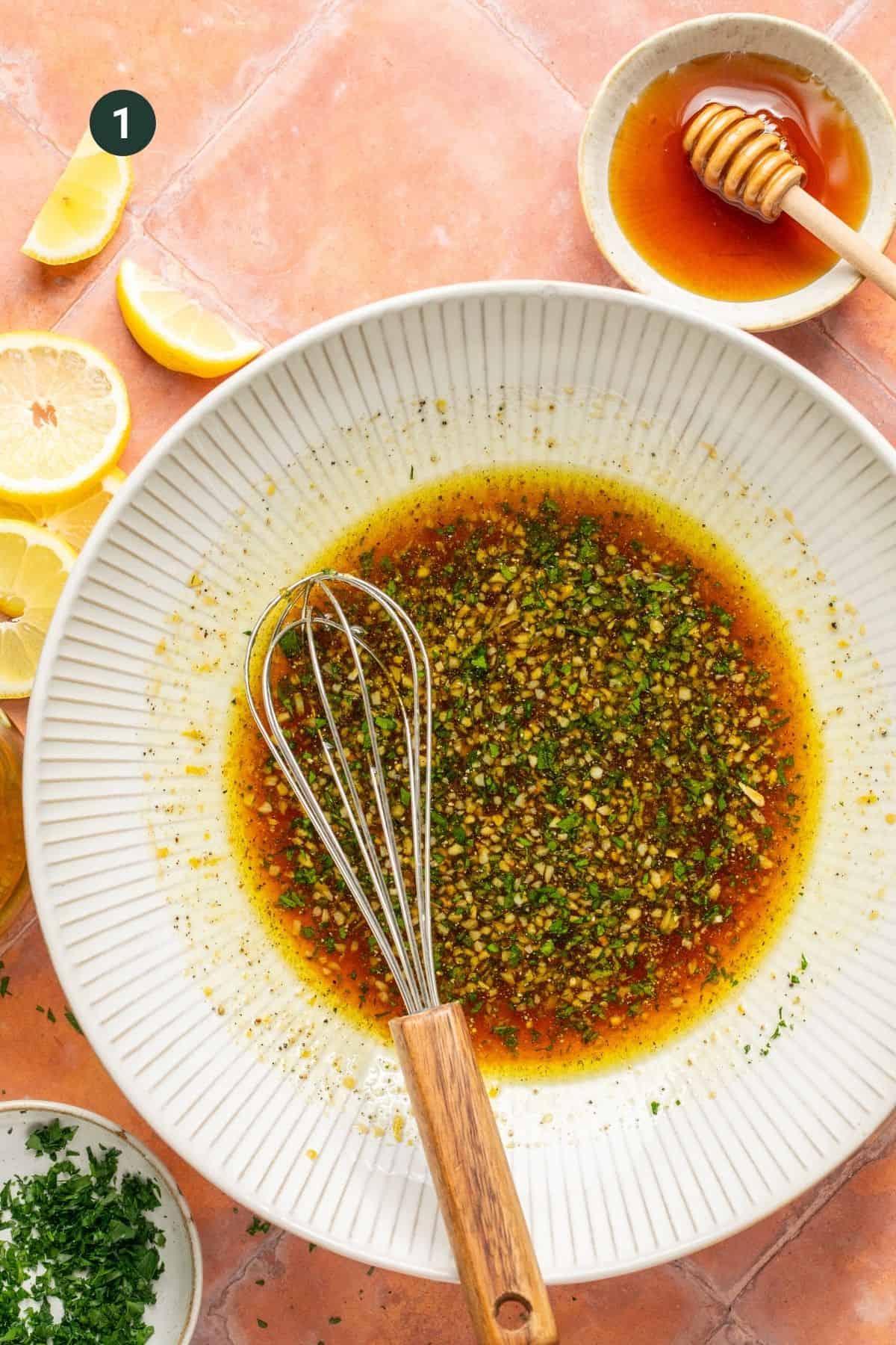 Honey, lemon juice and zest, coconut aminos, olive oil, salt and pepper in a bowl. 