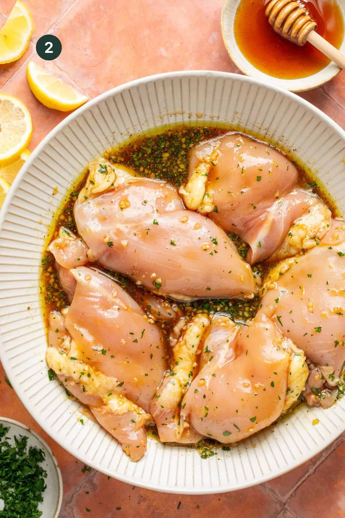 Chicken thighs in a bowl with the marinade.