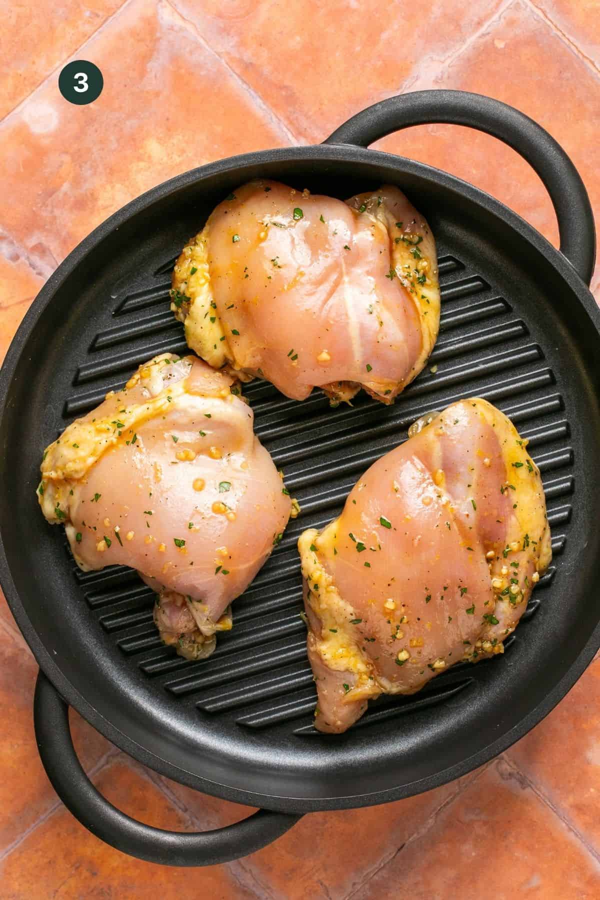 Marinated chicken thighs on a grill pan.