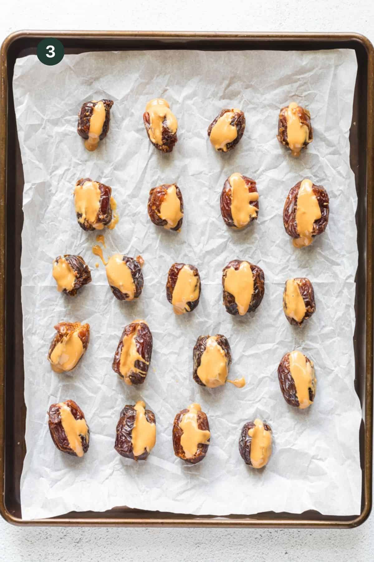 Prepped peanut butter filled dates on a baking sheet to freeze. 