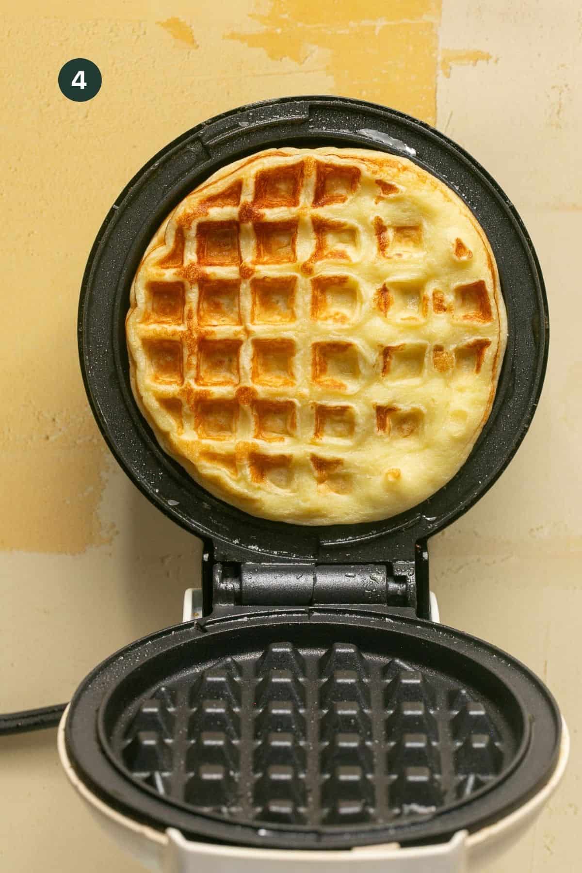 Browned and cooked waffle in a small single waffle maker.