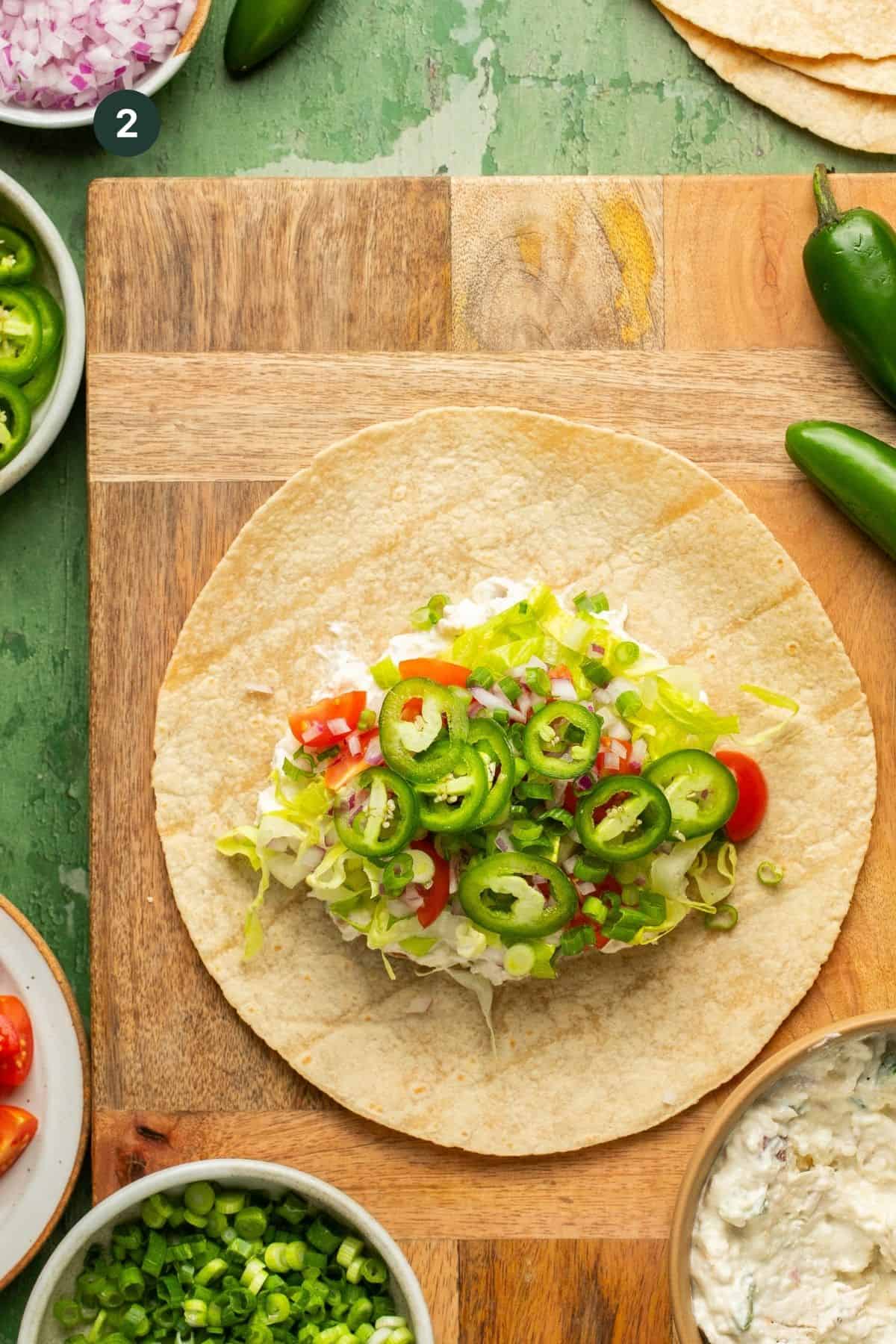 Lettuce, tomato, jalapenos and red onion added to the tortilla.