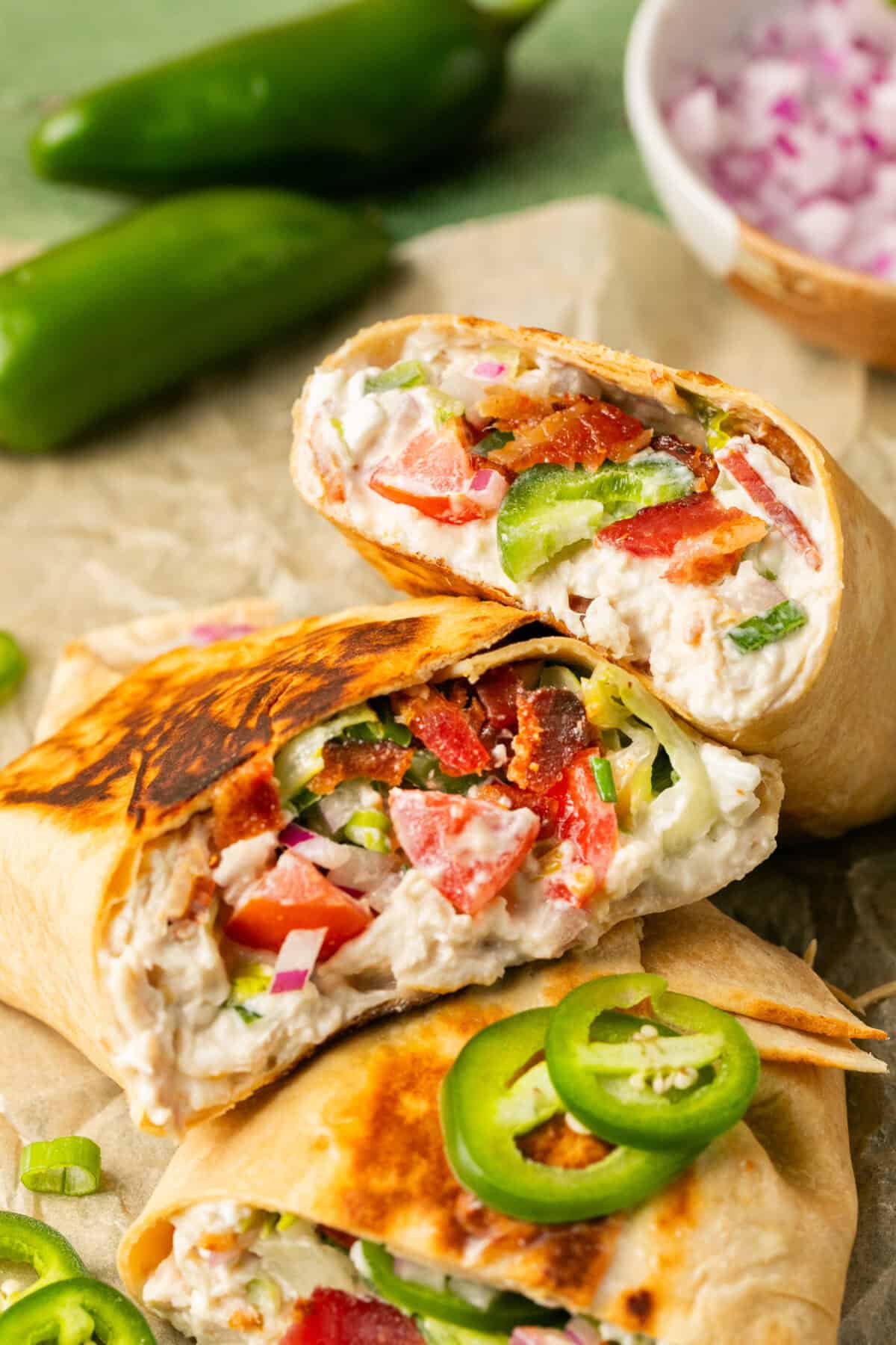 3 wraps stacked full of chicken dip, bacon, tomatoes and jalapenos. 