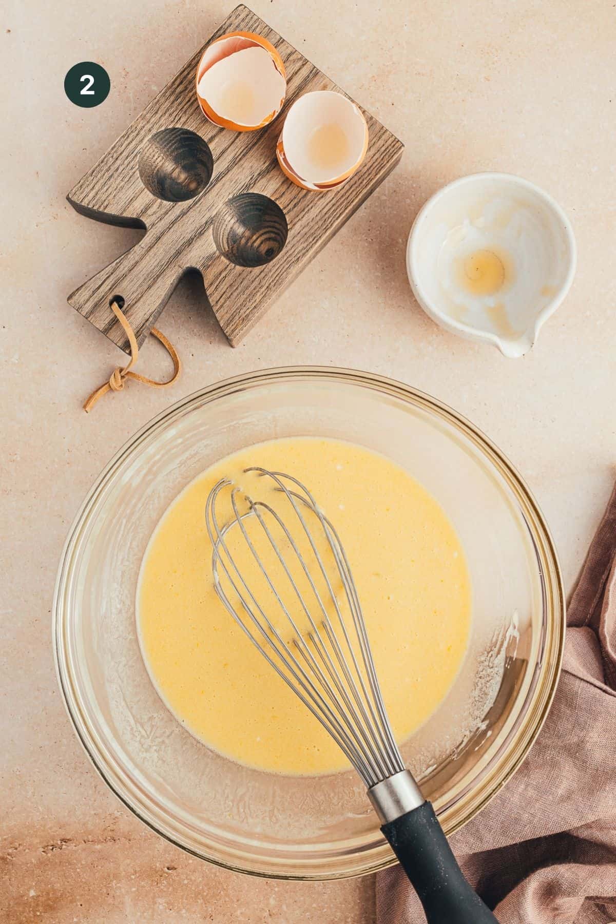 Wet ingredients combined in a mixing bowl for muffins with a whisk.