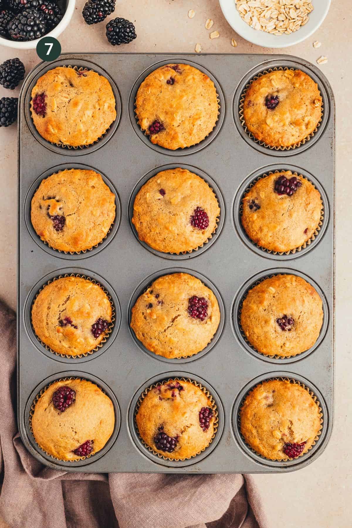 Fully cooked and browned muffins in a muffin pan cooling.