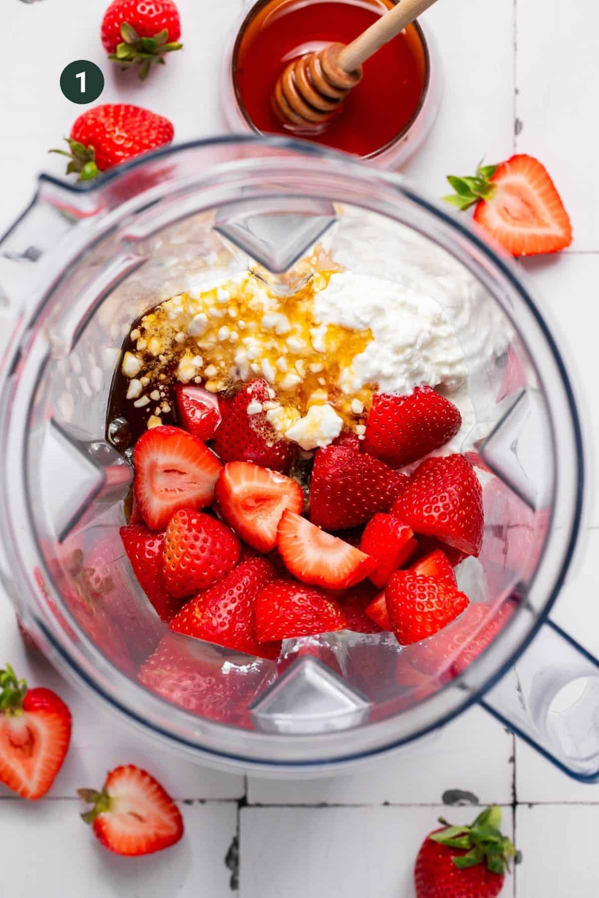 Fresh strawberries, honey and cottage cheese in a blender base.