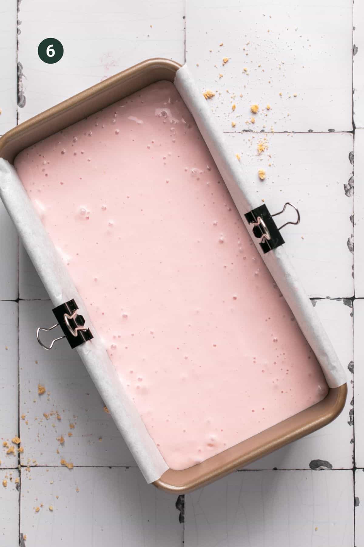 Cottage cheese strawberry ice cream mixture poured over the graham crackers in the load pan.