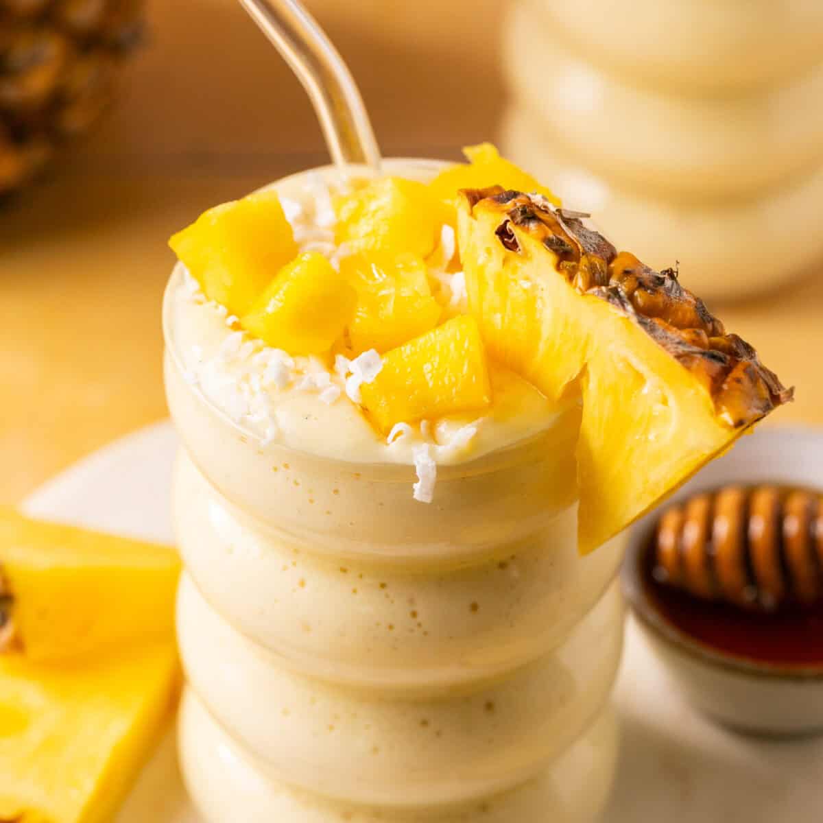 Smoothie topped with fresh pineapple and coconut flakes.