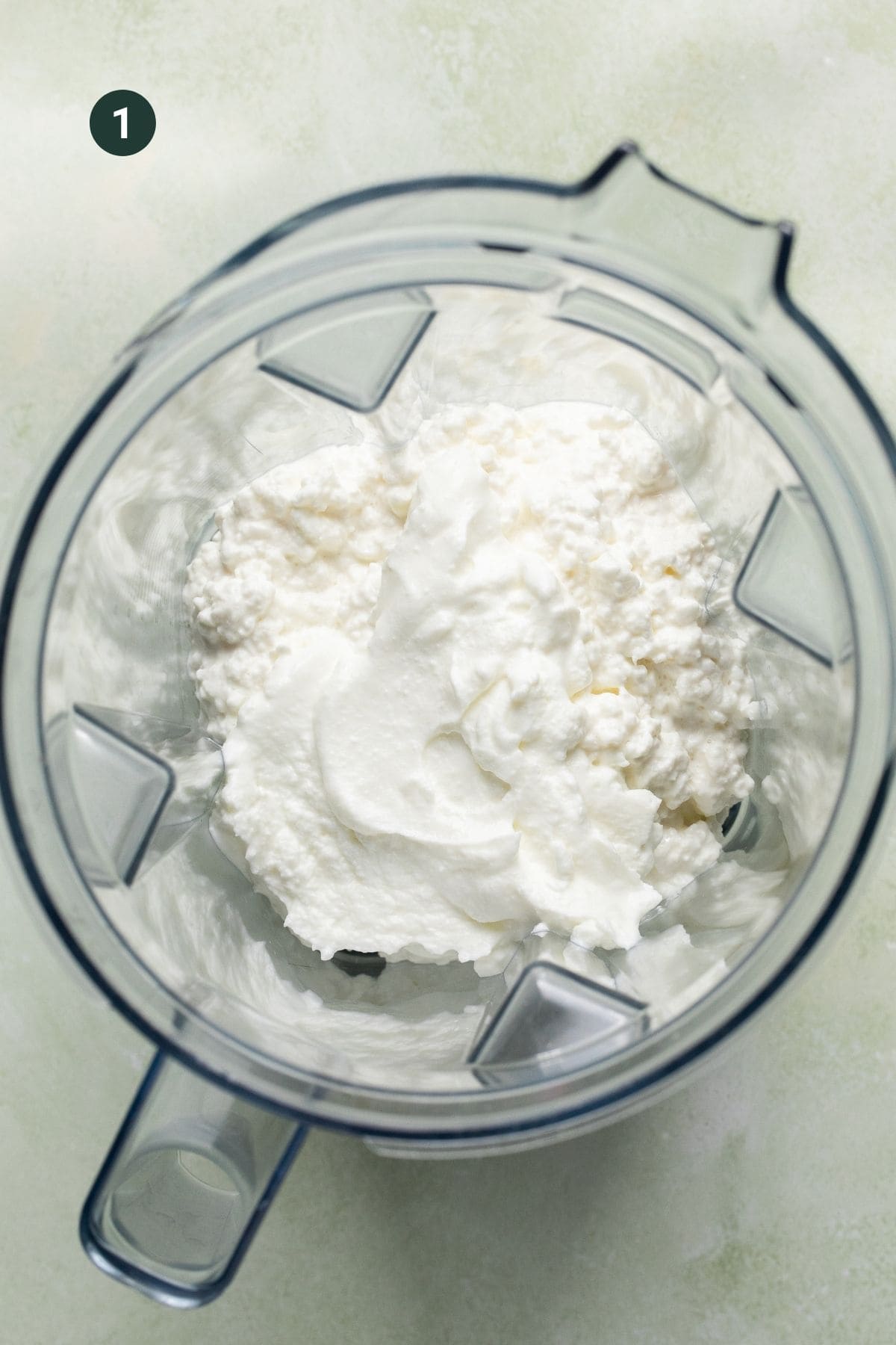 Greek yogurt and cottage cheese added to a blender. 