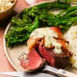 Perfectly cooked filet wrapped in bacon and topped with melted gorgonzola with a side of mashed potatoes and broccoli.