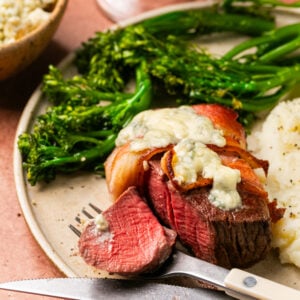 Perfectly cooked filet wrapped in bacon and topped with melted gorgonzola with a side of mashed potatoes and broccoli.