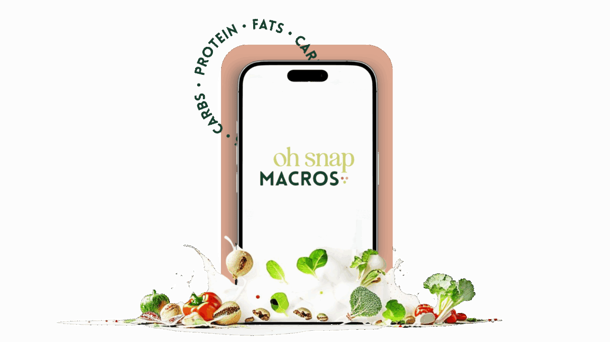 A smartphone displays the oh snap MACROS logo, surrounded by fresh vegetables, nuts, and herbs. The words CARBS โข PROTEIN โข FATS are arranged in a semicircle above the phone.