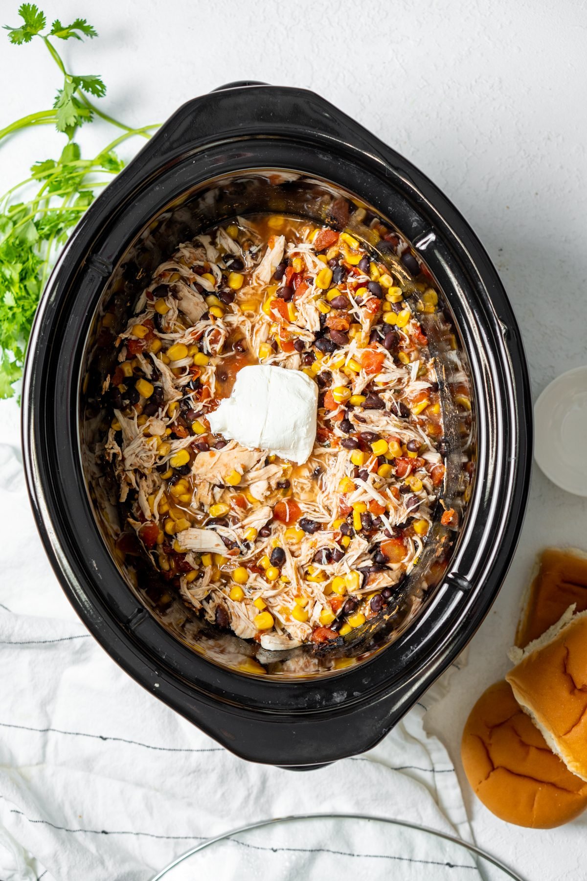 Southwest Chicken topped with cream cheese in a Crockpot.